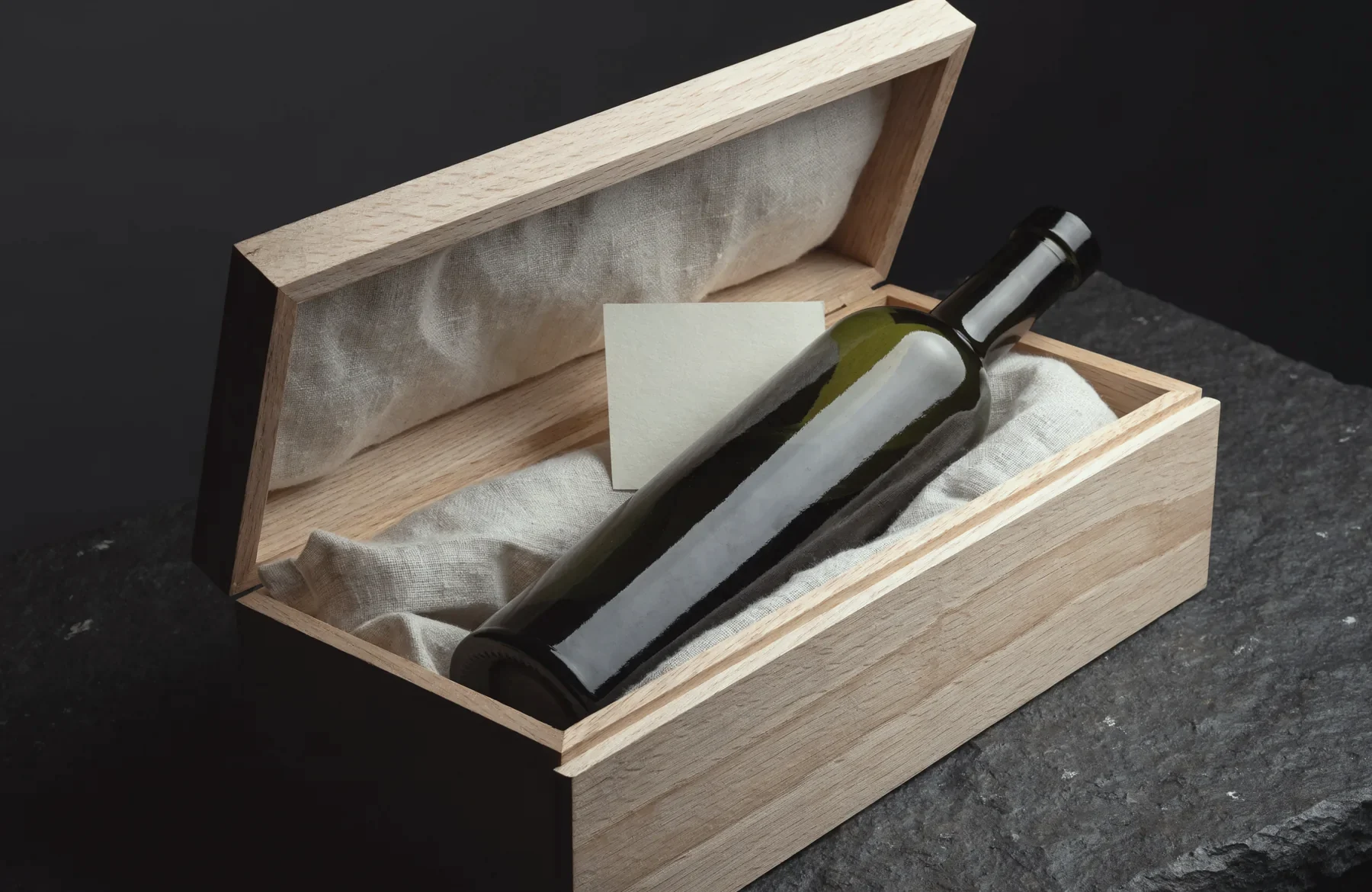 Eine Flasche Farga Milenario in einer offenen Kassette aus heller Eiche mit Leinen und Karte