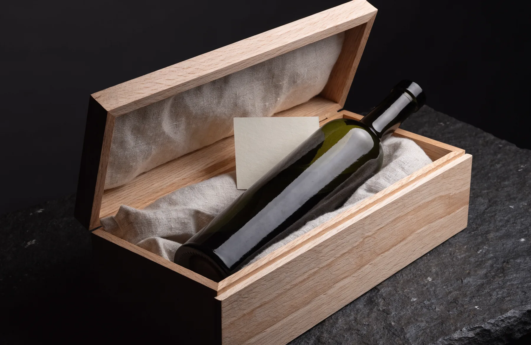 Eine Flasche Farga Milenario in einer offenen Eichenkassette mit Leinen und Karte